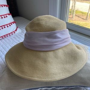 Packable wide brim hat with lilac colored ribbon.